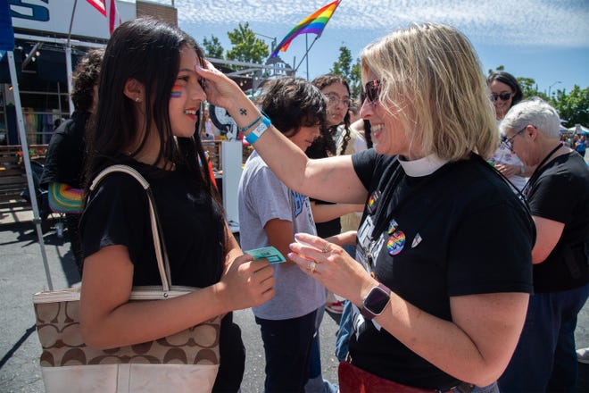 Rev. Betsy McElroy gives a glitter blessing to a young festival-goer at the 2026 Lodi Pride Festival